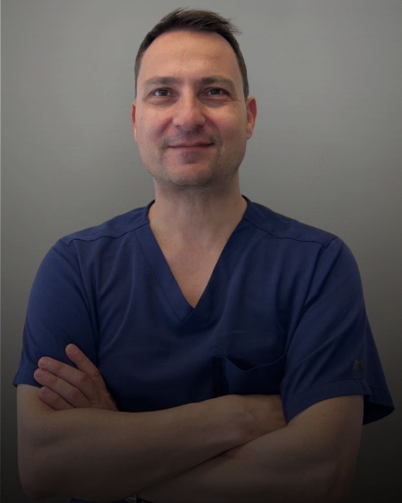 Портрет на лекар по дентална медицина, орален хирург и лицево-челюстен хирург, с тъмна медицинска униформа, заснет на неутрален фон.